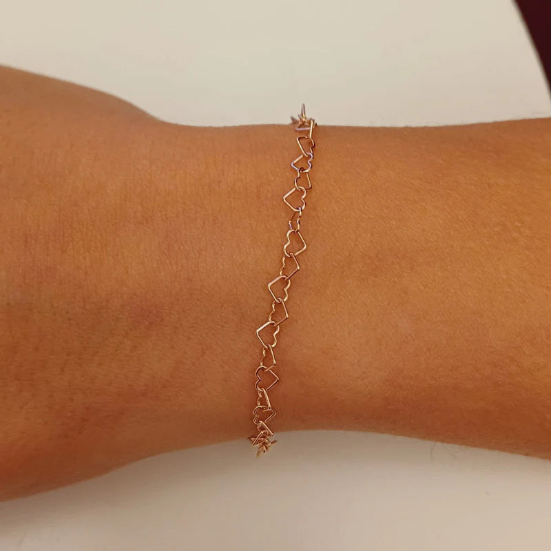Bracciale in maglia con cuore in argento indossato al polso