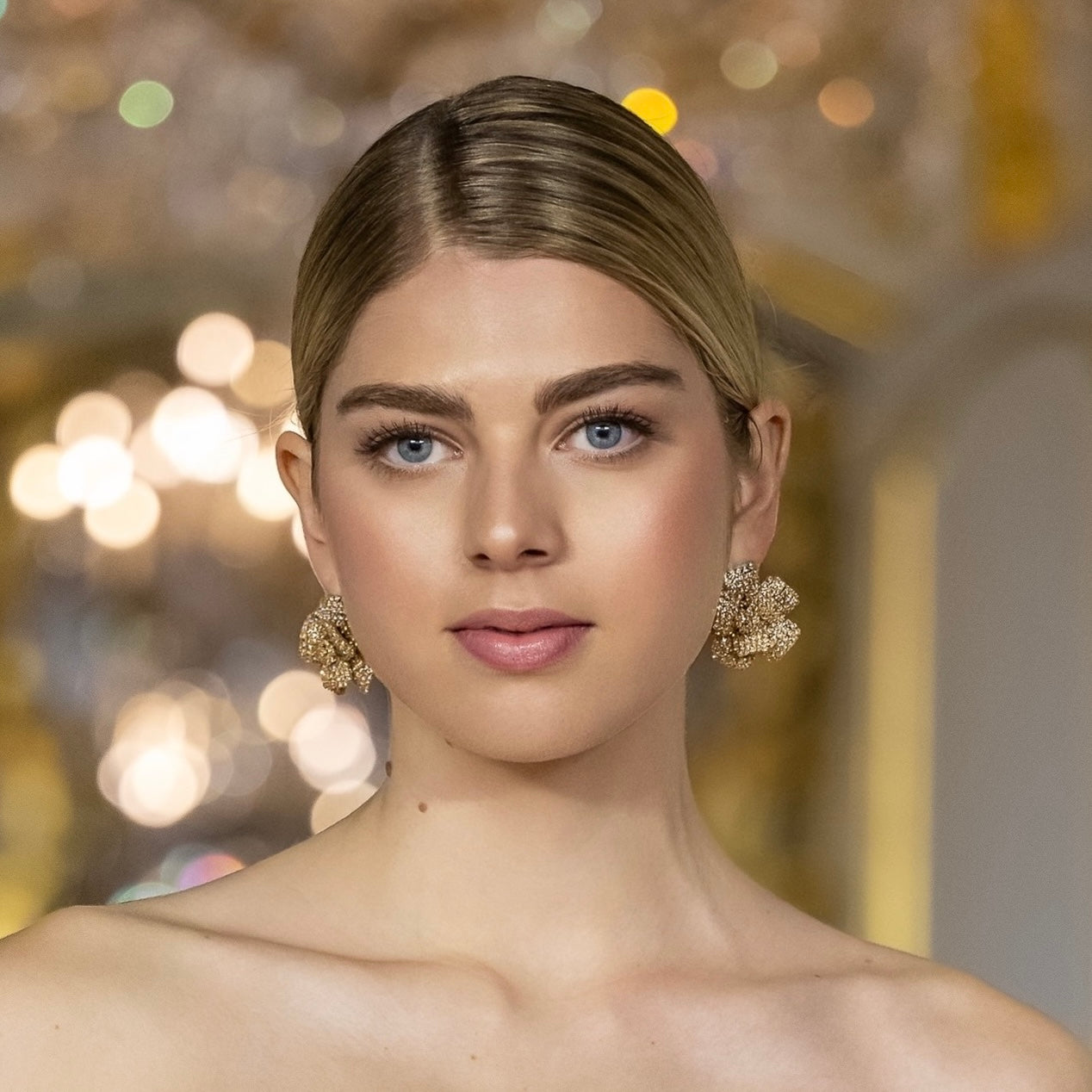 orecchini a forma di fiore con swarovski color oro indossati