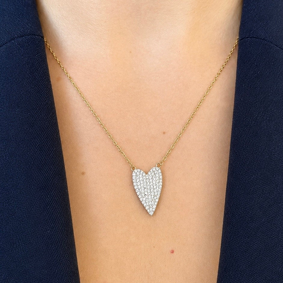 collana con ciondolo grande a cuore in zirconi e dettagli oro indossata