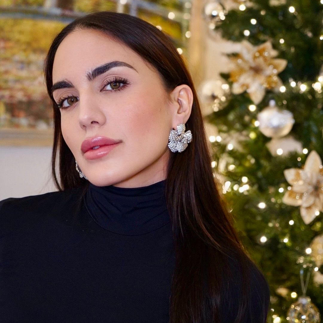 orecchini a forma di camelia con zirconi luminosi indossati