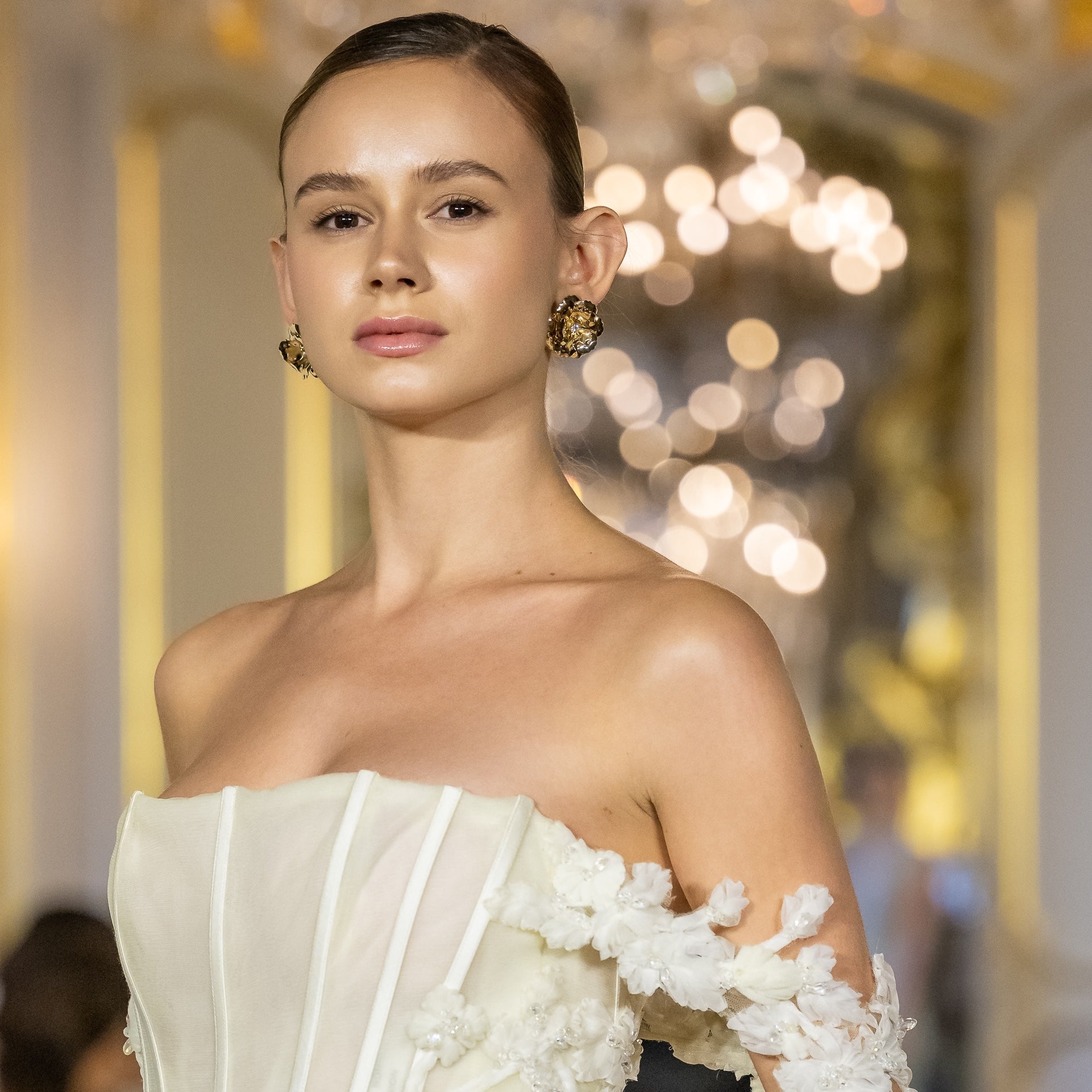 orecchini camelia color oro indossati con abito da sposa