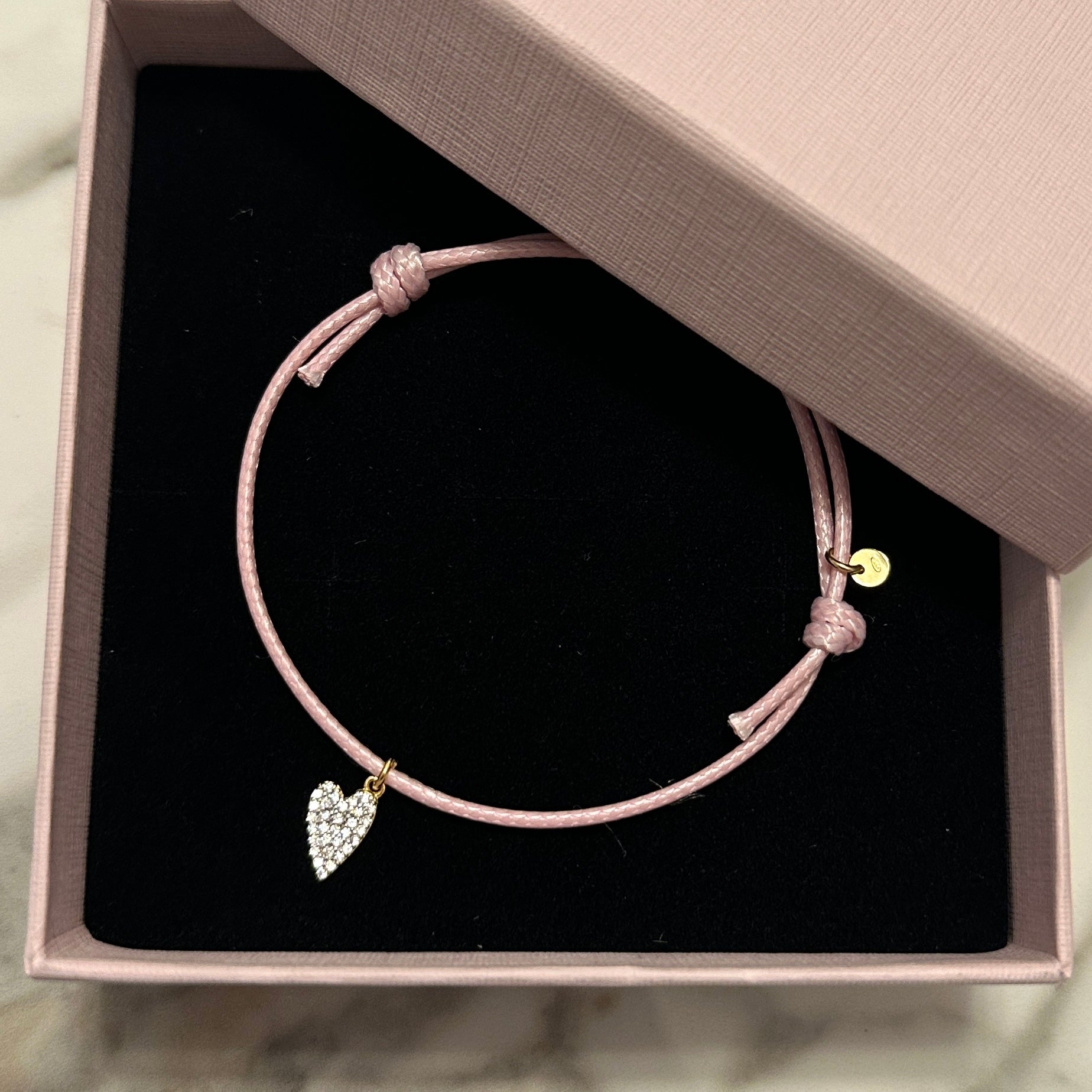 bracciale cordino rosa con charm cuore argento tempestato di zirconi come idea regalo
