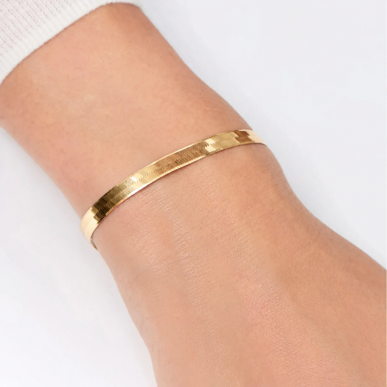 bracciale in oro spesso a spina di pesce indossato
