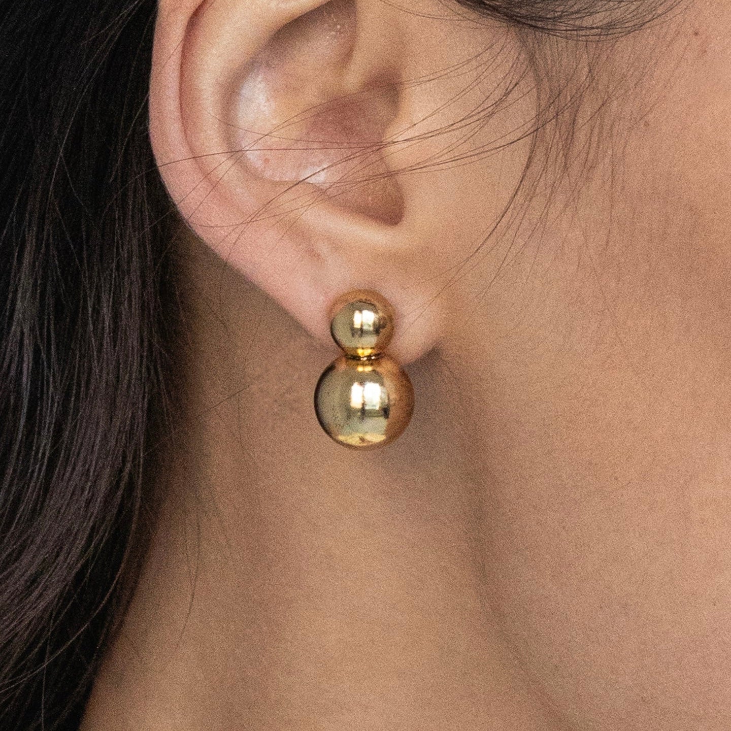 orecchini a forma di bolle dorate indossate