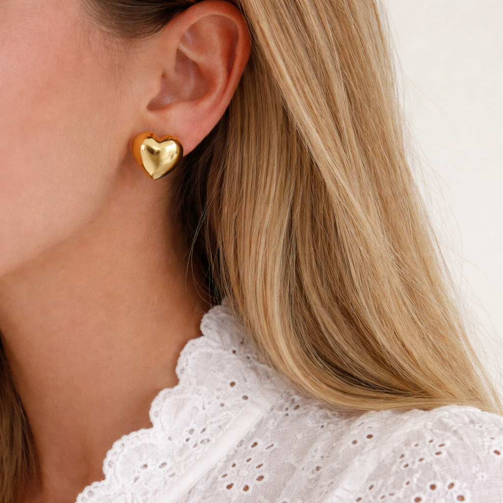 orecchini a forma di cuore bombato color oro indossati