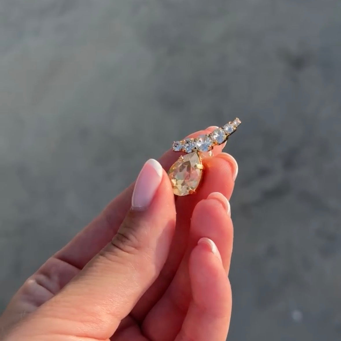 orecchini con cristallo a goccia oro e piccole pietre luminose in rifiniture oro