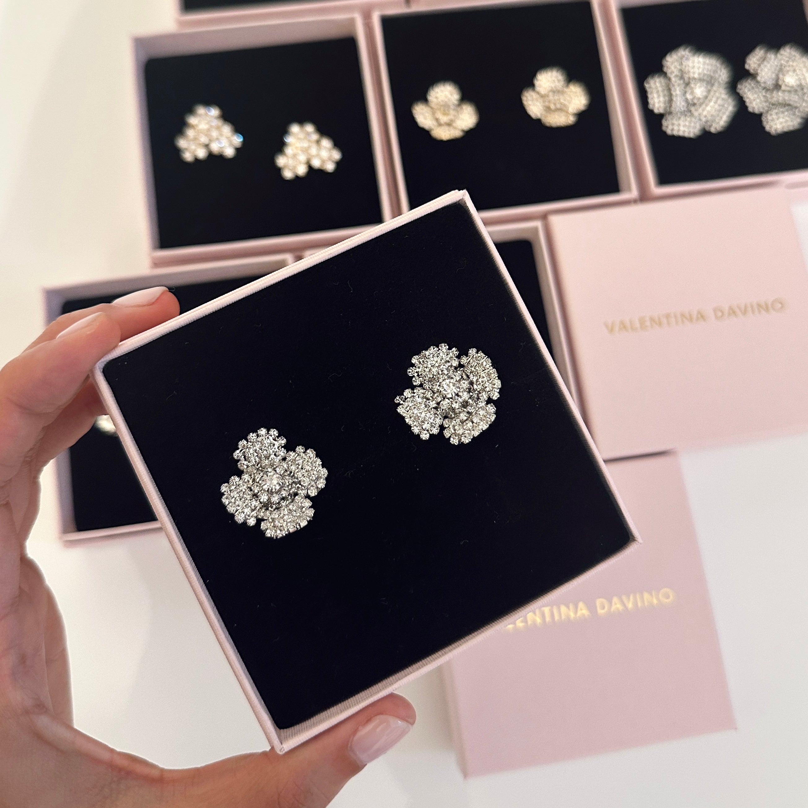 orecchini a forma di fiore color argento con zirconi incastonati indossati