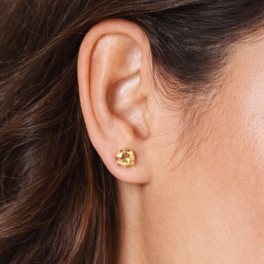 orecchino punto luce giallo indossato con capelli castani