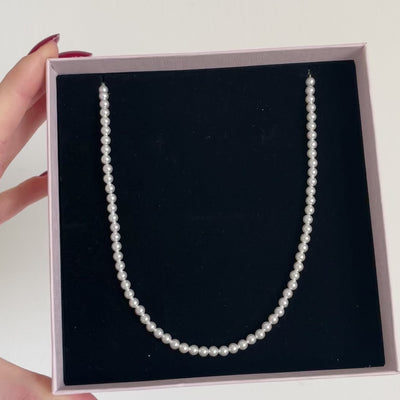 Collana di perle bianche piccole con rifiniture oro in packaging 