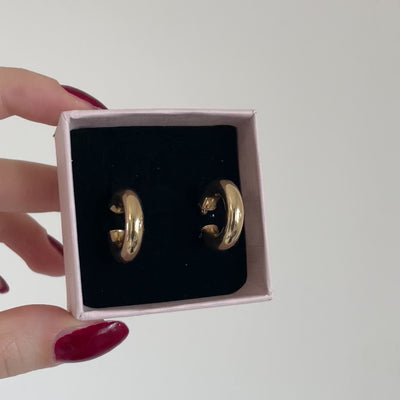 orecchini a cerchio spessi in oro nel packaging rosa chiaro