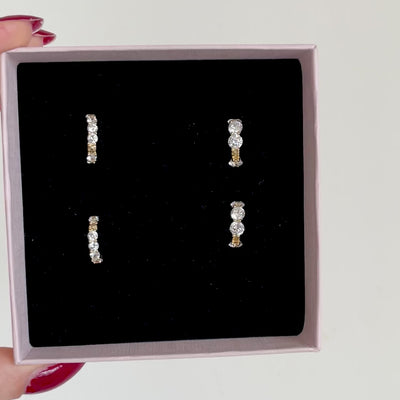 due paia di orecchini a cerchio con zirconi argentati di due dimensioni diverse 