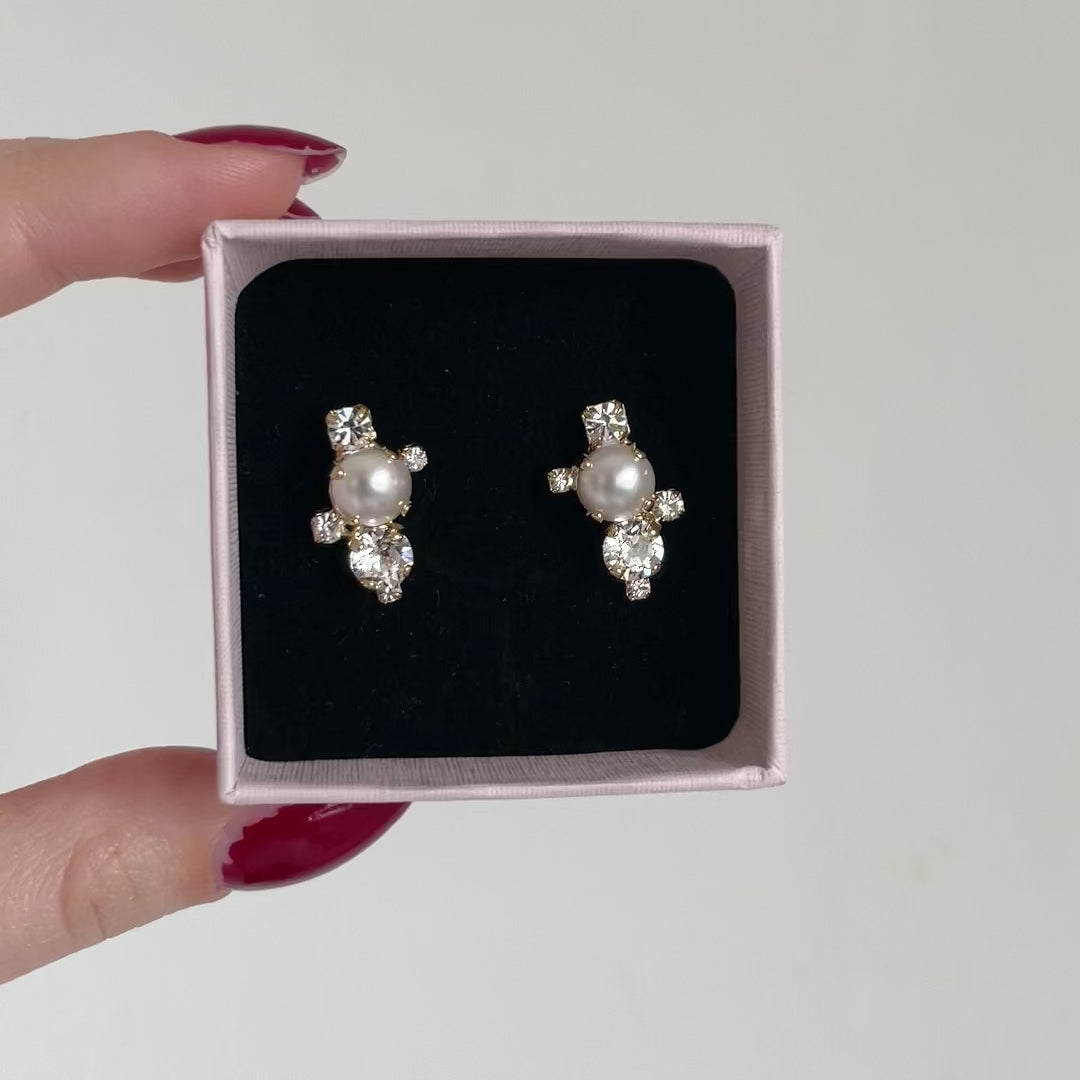 orecchini a lobo con perla centrale e swarovski piccoli attorno in packaging rosa 