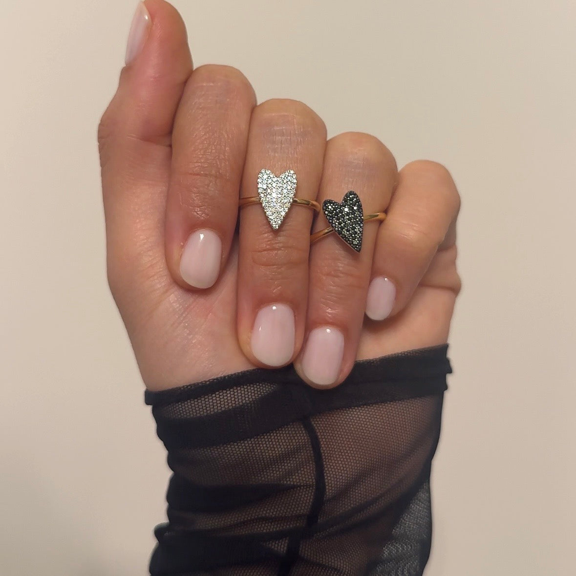 set anelli cuore con zirconi argento e cuore con zirconi nero su mano modello indossati 